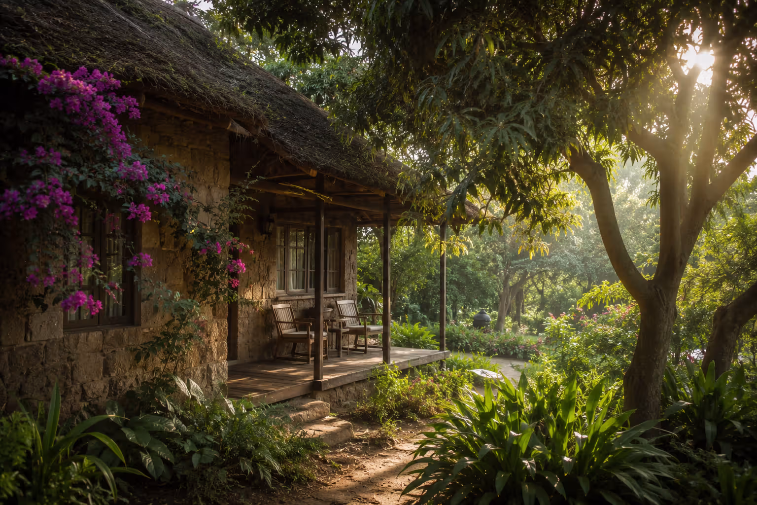 Stone and thatch cottage with bougainvillea and tropical garden in Kisumu, Kenya
